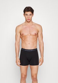 Sorte boxershorts lavet af blødt stof, med en logoet elastisk waistband, tætsiddende pasform og minimalistisk design.