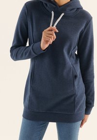 Námořnická modrá mikina s kapucí vyrobená z měkké tkaniny, s klokaní kapsou a nastavitelnými šňůrkami s bílým a černým vzorem.