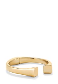 Pulsera de puño en tono dorado con una superficie lisa y pulida. Presenta extremos abiertos con acentos cuadrados y un diseño redondeado y flexible.