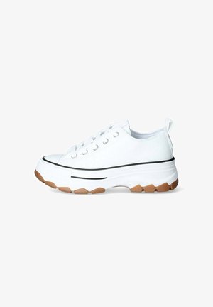 Zapatilla de lona blanca con una suela gruesa blanca, detalles en negro y una parte inferior de goma texturizada. Cuenta con punta redonda y cordones planos.