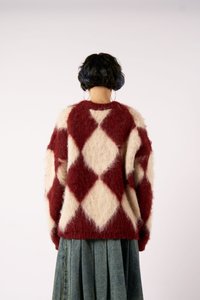 Piros és krém színű, túlságosan nagy pulóver, gyémántmintával, puha anyagból készült. A hátán kerek nyakú és laza ujjaival rendelkezik.
