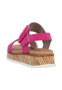 Różowe zamszowe sandały z szerokim paskiem i regulowanym zapięciem, charakteryzujące się platformą o strukturze korka z białą gumową bazą.