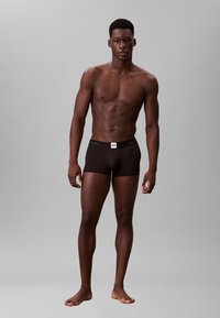 Boxer briefs neri in cotone con un ampio elastico in vita che presenta il logo bianco di Calvin Klein. Texture liscia, design aderente e lunghezza delle gambe corta.