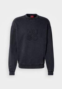 Czarny sweter z okrągłym dekoltem, z wytłoczonym logo "HUGO". Miękka faktura, ściągacze przy mankietach i u dołu, luźny krój.