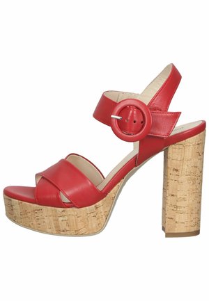 Røde læderplatformsandaler med krydsrem, rund spænde og korkhæl for stabilitet og højde. Glat tekstur.