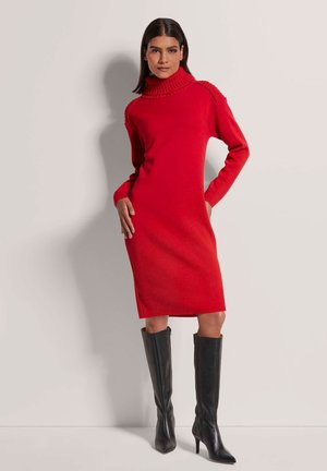 Rotes Rollkragenkleid mit gerippten Akzenten, figurbetontes Design, knielang, kombiniert mit hohen schwarzen Lederstiefeln mit Absatz. Glatte Textur.