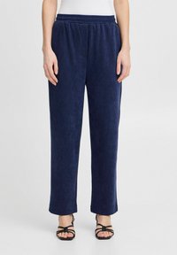 Pantalons en velours côtelé navy avec une taille élastique, coupe droite et poches latérales. Texture douce avec un motif à nervures subtil.