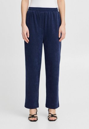 Pantalons en velours côtelé navy avec une taille élastique, coupe droite et poches latérales. Texture douce avec un motif à nervures subtil.