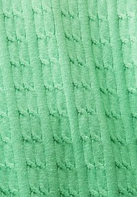 Grünes Strickgewebe mit einem strukturierten Muster aus ineinander verschlungenen Schlaufen und Ketten, das einen weichen, erhabenen Effekt erzeugt.