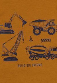 Oranger Stoff mit grafischen Darstellungen von Baumaschinen: Bagger, Muldenkipper, Kran und Betonmischer, mit dem Text "GROßE TRÄUME BAUEN" darunter.