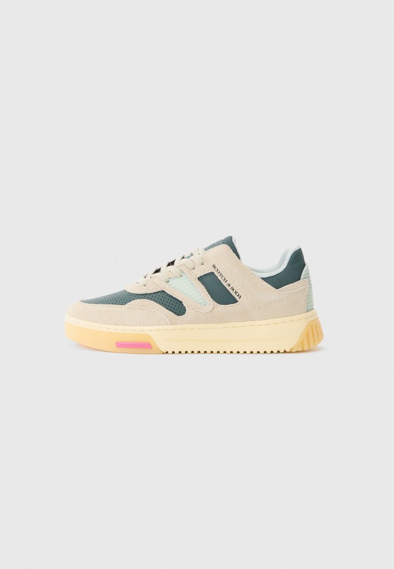 Baskets avec une tige en daim beige, des accents en maille verte et une semelle en caoutchouc. Présente une semelle intermédiaire jaune et un détail de logo rose au niveau du talon.