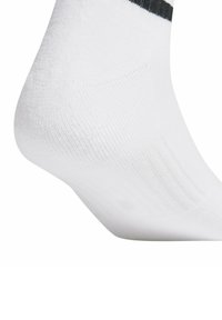 Biała bawełniana skarpetka o rypsowym wzorze, z czarnym pasek u góry. Pięta jest wyprofilowana, co podkreśla dopasowany krój.