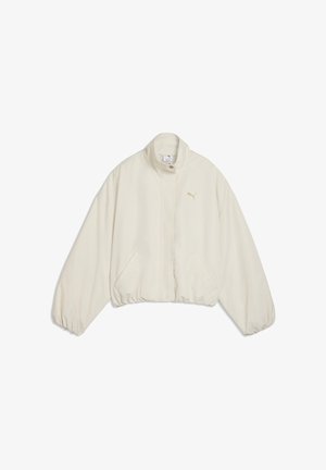 Chaqueta beige claro con cremallera, cuello alto, cintura y puños elásticos, bolsillos laterales y pequeño logo de Puma en el lado izquierdo del pecho.