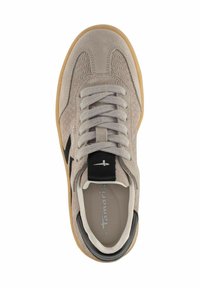 Beige Wildleder Sneaker mit strukturierten Seitenpaneelen, schwarzem Logo-Streifen, weißen Schnürsenkeln, schwarzem Fersendetail und Gummi-Sohle, von oben betrachtet.