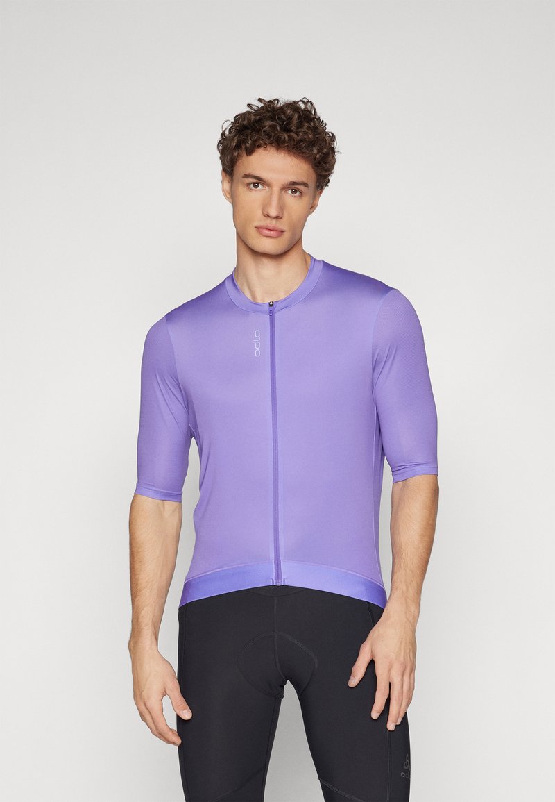 Krátky rukáv cyklistická dres v svetlo fialovej farbe, so zipsom na prednej strane, hladkou textúrou a priliehavým strihom. Logo zobrazené na hrudi.