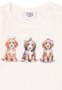 Helles T-Shirt mit drei abgebildeten Welpen mit Schleifen. Weicher Baumwollstoff, Rundhals und Druckknöpfe an der Schulter.