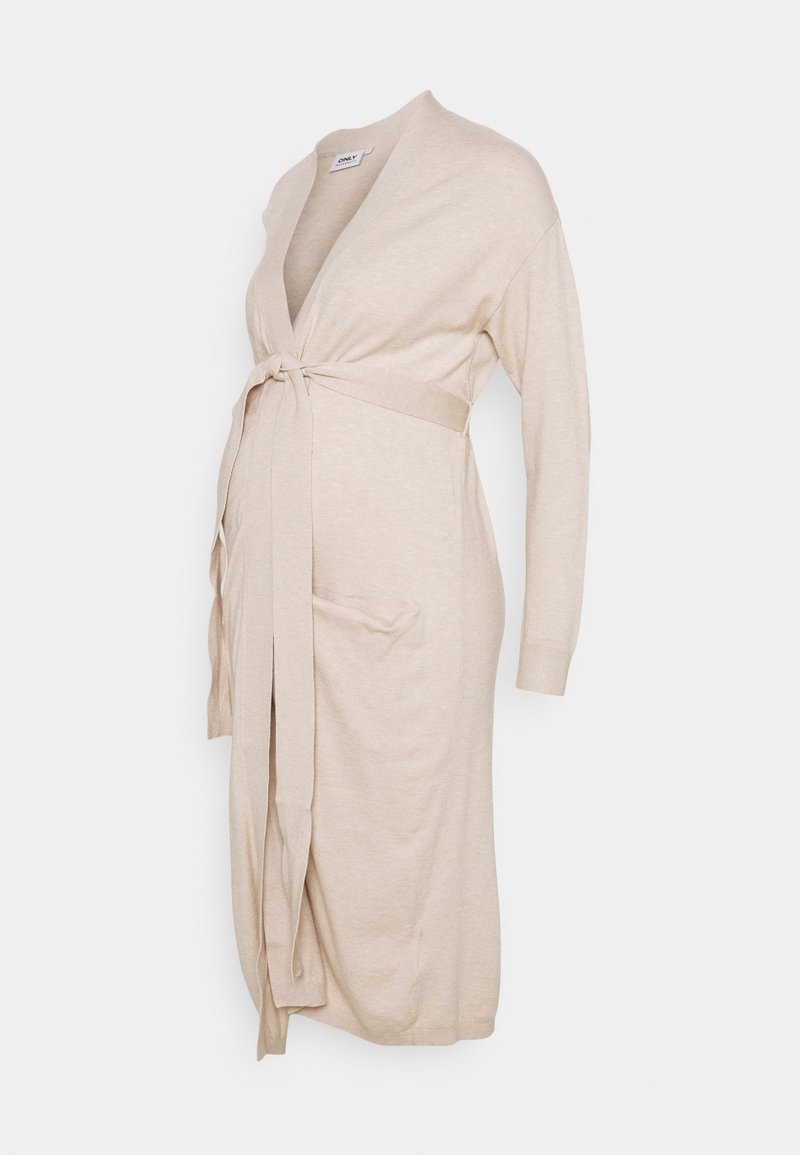 Cardigan lungo beige con maniche lunghe, chiusura a fiocco in vita e due tasche frontali. Realizzato in morbido tessuto a maglia testurizzata.