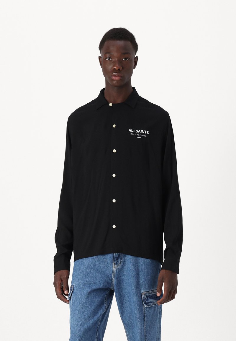 Zwarte langemouwen shirt met een button-down kraag, voorzien van witte "ALLSAINTS" tekst aan de linkerkant en parelachtige knopen. Casual ontwerp.