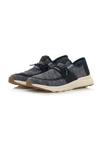 Zapatillas deportivas con parte superior de punto gris oscuro texturizado, cordones elásticos y suela de goma beige, con un diseño de perfil bajo.