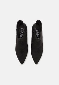 Black suede ankle boots with pointed toes, side zippers, and a smooth texture; inside label reads "BIANC."
