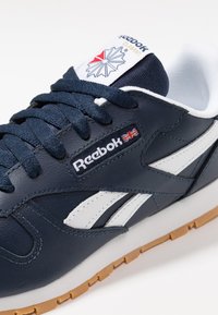 Sneaker in pelle blu con accenti bianchi, dotata di logo Reebok e suola in gomma textrurata. Chiusura con lacci e linguetta imbottita.