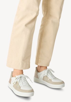Sneakers med en blandning av vit läder och beige mocka, med en strukturerad yta, platt vit sula och framträdande vita snören.
