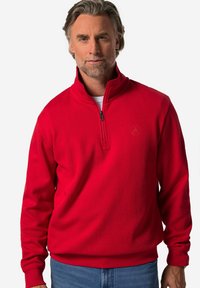 Roter Zip-Up-Pullover mit hohem Kragen, aus weichem Stoff gefertigt, mit gerippten Bündchen und Saum sowie einem kleinen Logo auf der Brust.