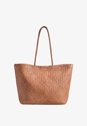 Brun flettet læder shoppertaske med lange flettede håndtag og en rummelig rektangulær form, vist mod en hvid baggrund.