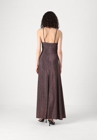 Rochie de seară lungă, fără mâneci, realizată dintr-un material bronzat închis strălucitor. Are bretele subțiri și un corset ajustat care se continuă cu o fustă evazată.