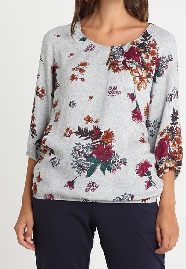 Floral blouse in light gray fabric featuring a round neckline, three-quarter sleeves, and colorful flower patterns in burgundy and yellow shades.