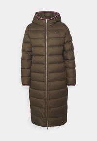Parka lunga di colore verde oliva con cappuccio, chiusura a zip e motivo trapuntato orizzontale. Presenta un rivestimento rosa a contrasto sui polsini.