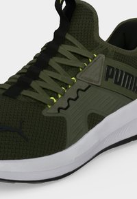 Πράσινο ελιάς sneaker Puma με επάνω μέρος από δίχτυ, ταιριαστά κορδόνια, μαύρο λογότυπο, νέον θηλιές κορδονιών και λευκή μαλακή σόλα.
