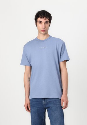 Világoskék pamut póló kerek nyakkivágással, rövid ujjakkal és a mellkason elhelyezett kis "TOMMY JEANS" logóval. Standard szabás.