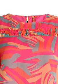 T-shirt à manches courtes présentant un motif de feuilles tropicales en rose vif, orange et teal avec un accent froncé sous le col.