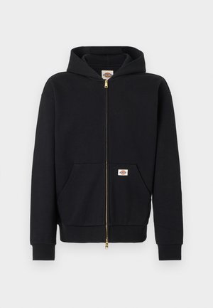 Črna majica s kapuco z zadrgo, sprednjimi žepi, rebrastimi manšetami ter logotipnimi značkami na prsih in žepu, prikazana na enostavni podlagi.