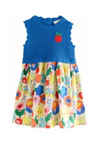 Bodice bleu au crochet avec des bords en vagues et une appliqué de pomme rouge ; jupe en coton à imprimé floral coloré avec divers motifs vibrants.