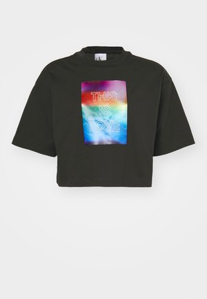 T-shirt noir raccourci à manches courtes avec un graphique rectangulaire aux couleurs de l'arc-en-ciel et le texte "C'EST ÇA L'AMOUR" en lettres blanches.