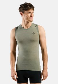 Light green sleeveless athletic top, textured fabric, round neckline, featuring a small black logo on the left chest area.