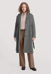 Grauer Wollmischmantel mit Reverskragen, einreihigem Schnitt und fünf Knöpfen. Dazu ein rosa Strickpullover und beige Hose.