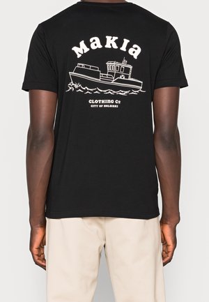 Schwarzes T-Shirt mit weißer Bootsillustration, darüber der Schriftzug „Makia“ und darunter der Schriftzug „Clothing Co City of Helsinki“ auf dem Rücken.