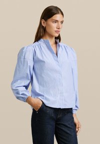 Lichtblauw gestreept shirt met poflange mouwen, een staande kraag en een knoopsluiting aan de voorkant. Gemaakt van gladde stof, heeft een relaxte pasvorm.