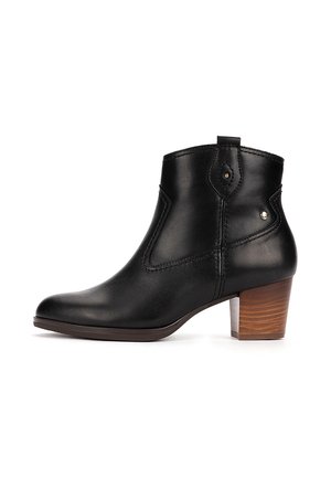 Bottine en cuir noir avec talon bloc en bois, détails de couture latérale et petits clous métalliques sur la partie supérieure, vue de profil.