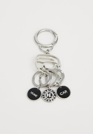Silver keychain with multiple rings. Features round black tags labeled "HOME" and "CAR," and a logo tag with a stylized letter "K."