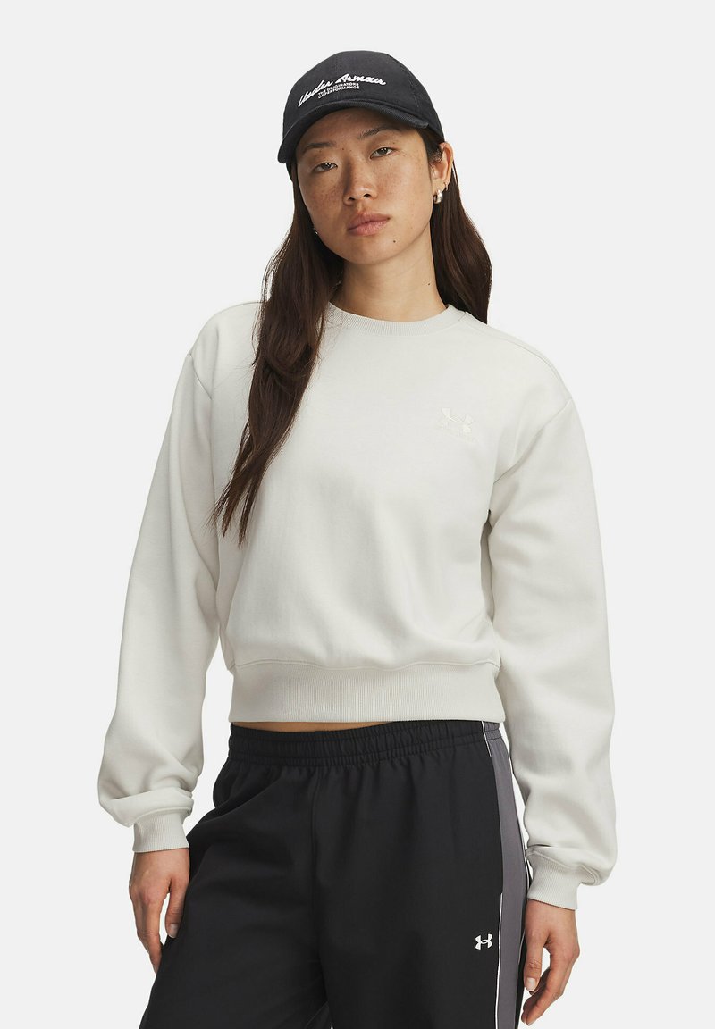 Felpa grigia chiara con maniche e orlo a coste, caratterizzata da un piccolo logo bianco sul petto. Abbinata a pantaloni sportivi neri con strisce laterali.