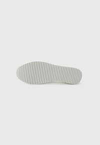 Talpa de pantof cu o suprafață netedă de culoare gri deschis, având un model texturat, cu dungi, pentru aderență pe partea inferioară.