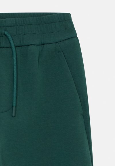 Mørkegrønne joggebukser med elastisk midjebånd og matchende snor, med en sidelomme på høyre bein.