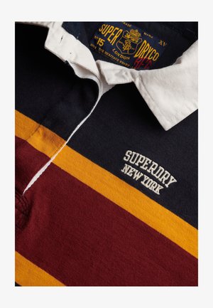 Rugby-shirt med krave med striber i marineblå, sennepsgul og bordeaux samt "Superdry New York" broderet på brystet.