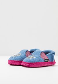 Blue felt slippers with pink rubber soles. Features a glittery silver star accent and elastic side panels for easy wear. Brand label visible.