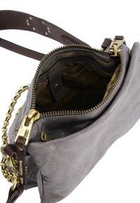 Grå læder crossbody taske med lynlåslukning, guldfarvet hardware og kædetræk. Indvendigt har den brun foring og lommer.