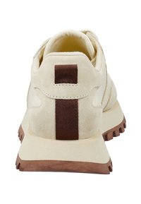 Beige Wildledersneaker mit einem braunen vertikalen Zugtab, gepolstertem Kragen und dicker brauner Gummisohle mit Profil.